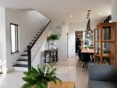 Spacious modern living room with elegant dining area and stylish staircase