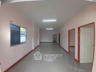 Spacious interior with glossy floors and pink walls, ideal for versatile living space.