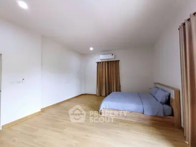Spacious minimalist bedroom with wooden flooring and natural light