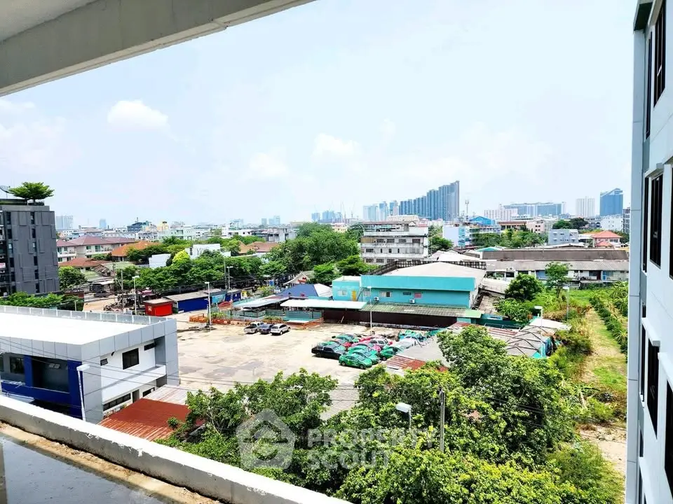 Stunning cityscape view from a modern apartment balcony, showcasing urban skyline and lush greenery.