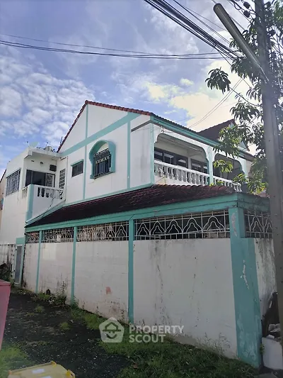 Charming two-story house with unique architectural details and spacious balcony, perfect for family living.