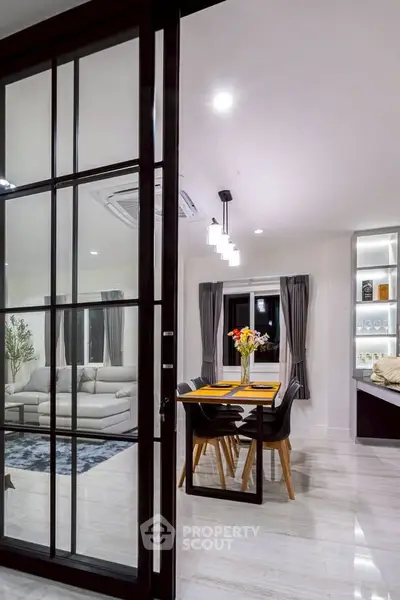 Modern open-plan living and dining area with elegant decor and ambient lighting.