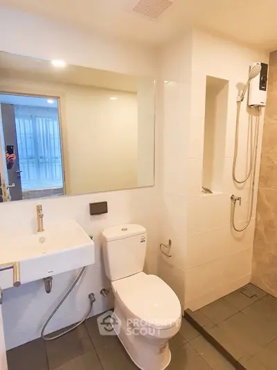 Modern bathroom with sleek fixtures and large mirror in a contemporary apartment.