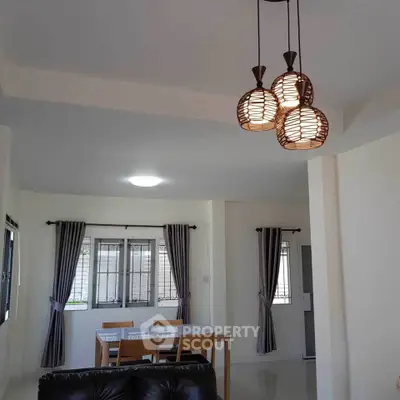 Modern dining area with stylish lighting and natural light from large windows.