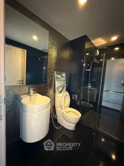 Modern bathroom with sleek fixtures and dark tile design