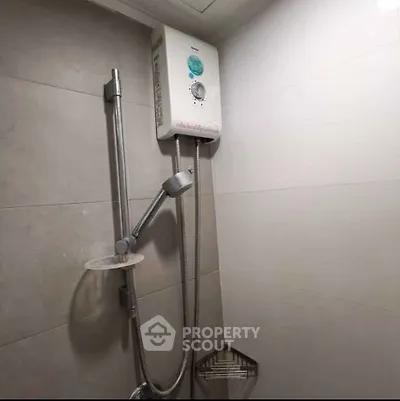 Modern bathroom with sleek shower and water heater in a minimalist design.
