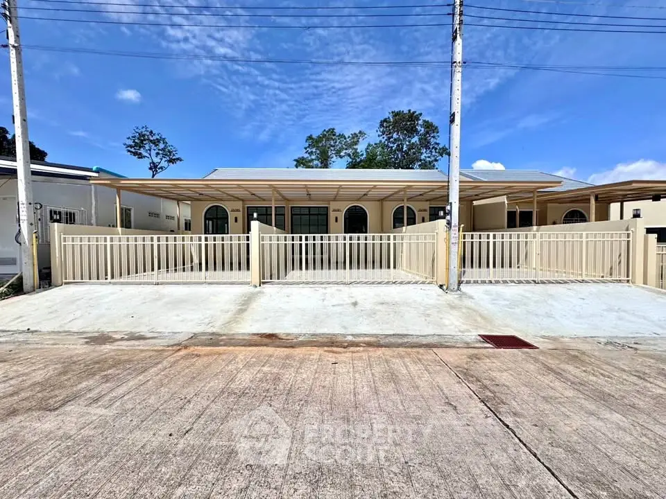Modern single-story house with spacious driveway and gated entrance