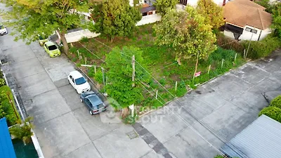 Prime corner lot in residential area with lush greenery and ample parking space.