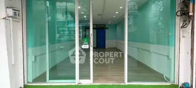 Spacious commercial space with glass facade and wooden flooring, ideal for retail or office use.