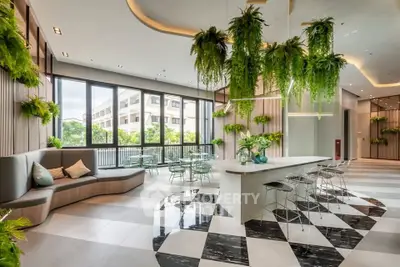 Modern living room with stylish decor and lush greenery, featuring a chic seating area and large windows.