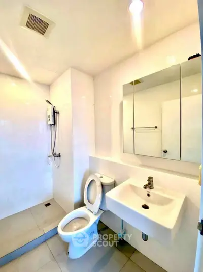 Modern bathroom with sleek white fixtures and spacious shower area
