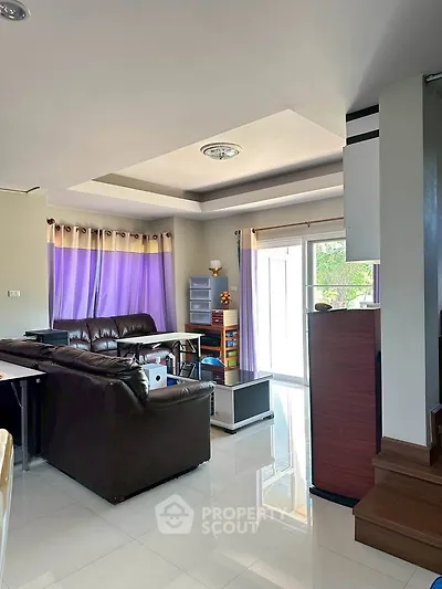 Spacious living room with modern decor and ample natural light, perfect for family gatherings.