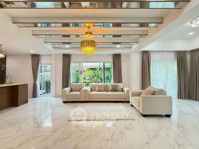 Luxurious open living room with elegant chandelier and marble flooring, perfect for modern living.