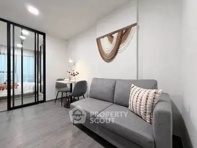 Modern living room with gray sofa and dining area in open layout apartment