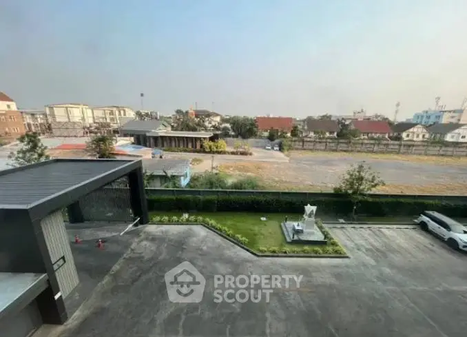 Spacious parking area with lush greenery and modern building entrance, ideal for residential or commercial use.