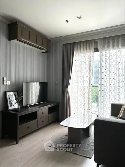 Modern living room with stylish decor and natural light from large window.