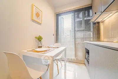 Modern kitchen with sleek design, featuring a compact dining area and large window for natural light.
