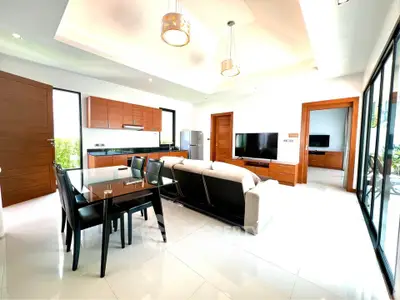 Spacious modern living room with open kitchen and elegant furnishings in a bright, airy setting.