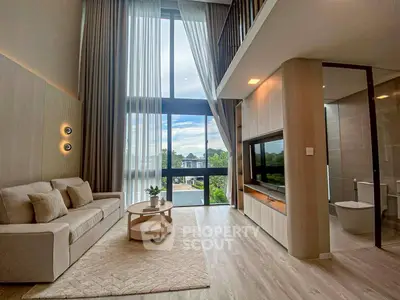 Luxurious modern living room with high ceilings and large windows offering stunning views.