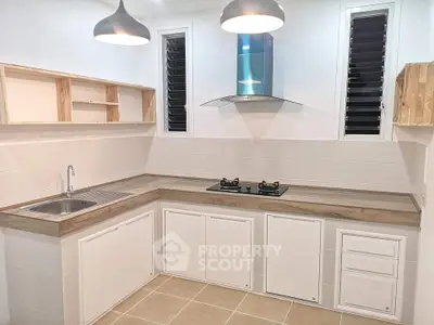 Modern kitchen with sleek cabinetry, gas stove, and stylish lighting, perfect for culinary enthusiasts.