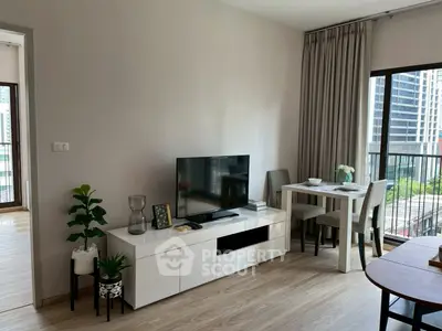 Modern living room with TV, dining area, and city view balcony in a stylish apartment.