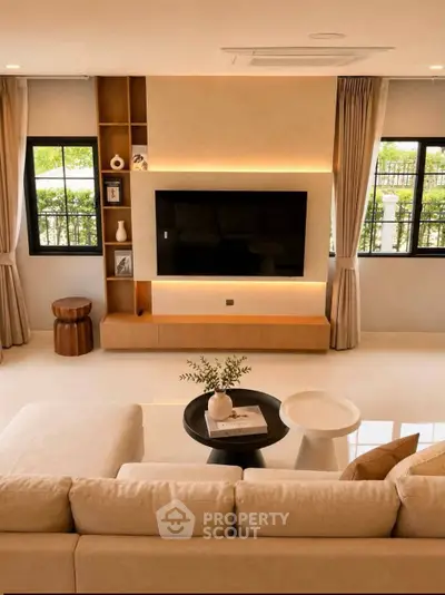 Luxurious living room with modern decor and large TV, perfect for relaxation and entertainment.