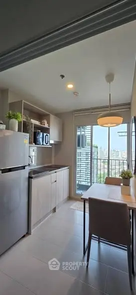 Modern kitchen with sleek appliances and city view from balcony, perfect for urban living.