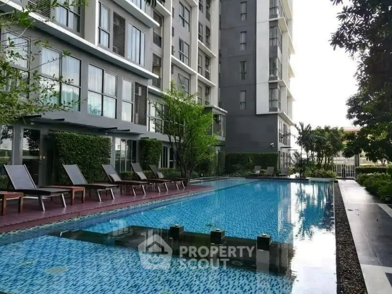 Luxurious apartment complex with a stunning outdoor pool and modern architecture.