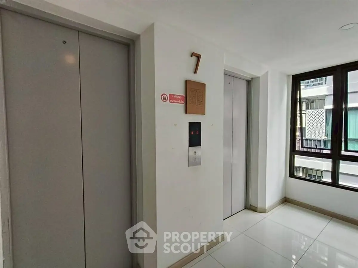Modern building elevator lobby with sleek design and natural light on the seventh floor.