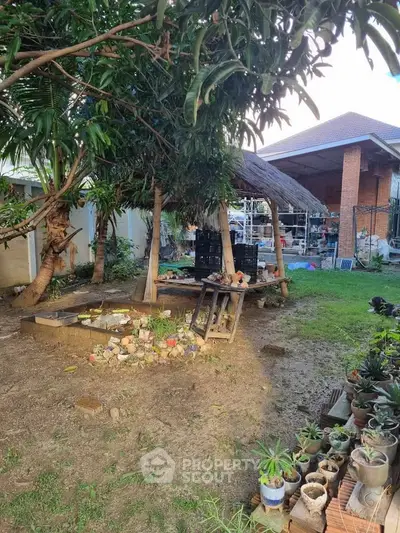 Charming backyard with lush greenery and rustic outdoor seating area.