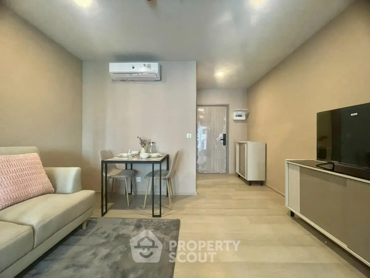 Modern living room with cozy sofa, dining area, and air conditioning.