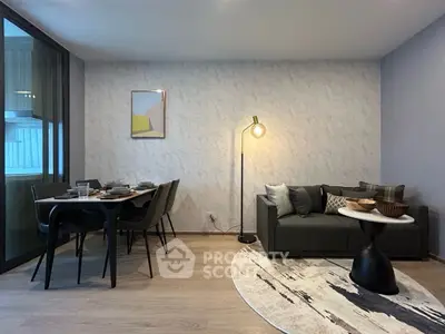 Modern living room with stylish decor and dining area, featuring a cozy sofa and elegant lighting.
