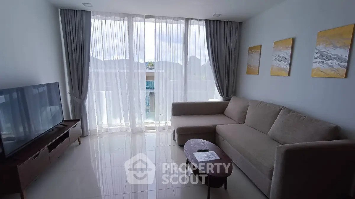 Modern living room with large windows, stylish sofa, and elegant decor in a bright apartment.