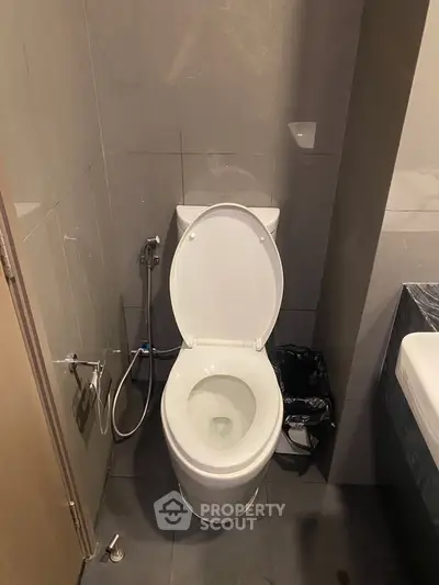 Modern bathroom with sleek toilet and gray tile design, perfect for contemporary living spaces.