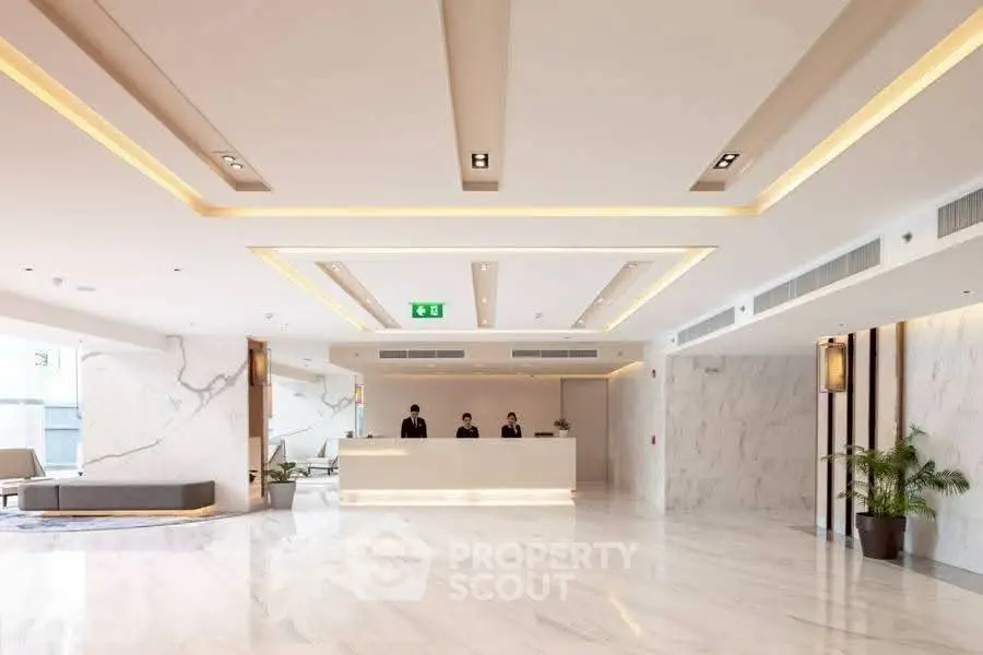 Luxurious hotel lobby with modern design and marble flooring, featuring a sleek reception desk and elegant lighting.