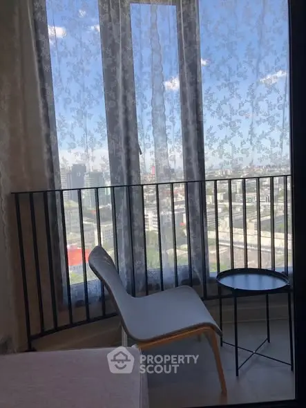 Charming balcony with city view, featuring elegant chair and table setup.