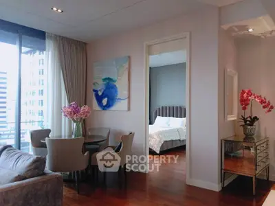 Elegant modern living room with dining area and view into cozy bedroom, featuring stylish decor and natural light.