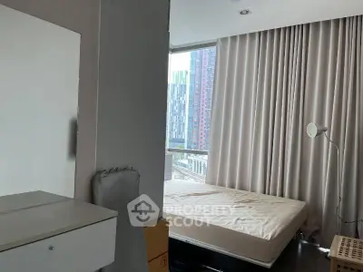 Modern bedroom with large window and city view, featuring minimalist decor and natural light.