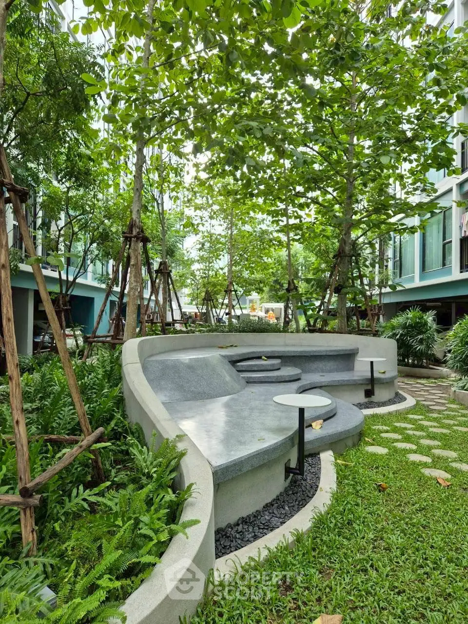 Lush garden seating area with modern concrete benches and greenery