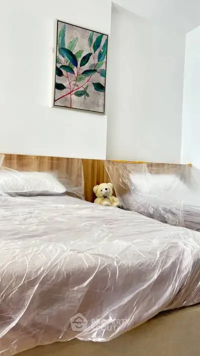 Cozy bedroom with modern decor and plush bedding, featuring a charming teddy bear accent.