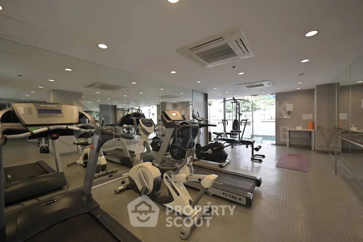 Modern gym with state-of-the-art fitness equipment and mirrored walls in a luxury residential building.