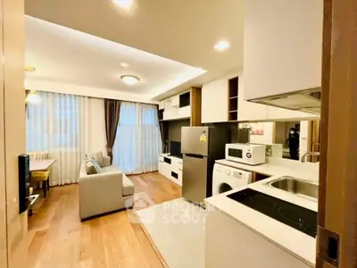 Modern open-layout kitchen and living area with sleek appliances and cozy seating.