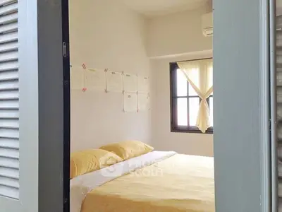Cozy bedroom with yellow bedding and natural light from window