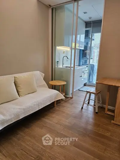 Cozy living room with wooden flooring and compact kitchen in modern apartment