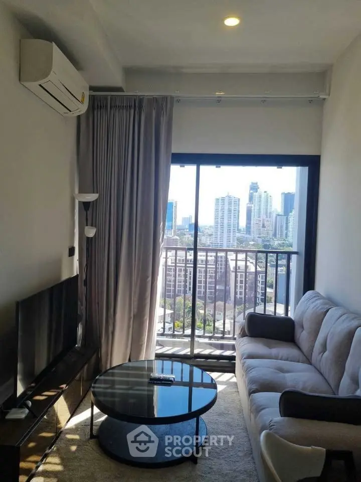 Modern living room with city view, featuring cozy sofa and sleek decor.