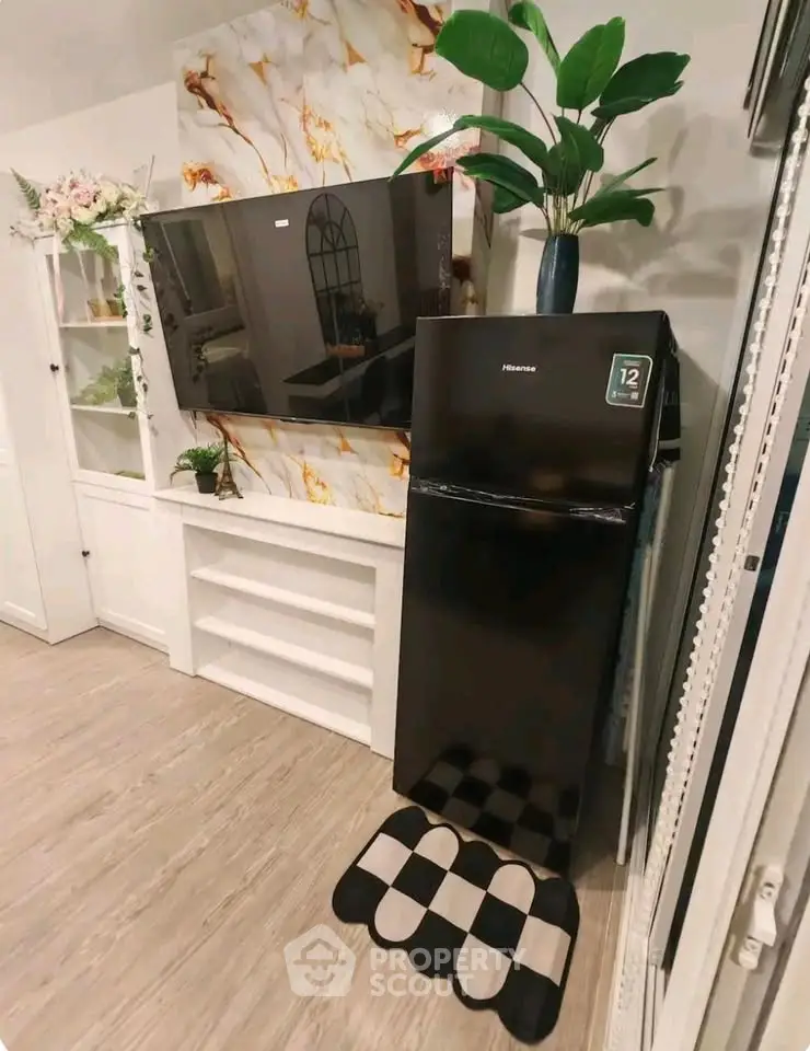 Stylish living room with modern decor and sleek black fridge, perfect for contemporary living.
