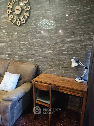 Cozy living room corner with stylish wooden desk and plush sofa, perfect for relaxation and work.
