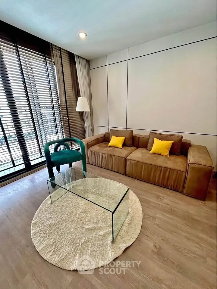 Modern living room with stylish furniture and large windows offering natural light.