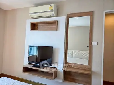 Modern bedroom with wall-mounted TV and air conditioning unit