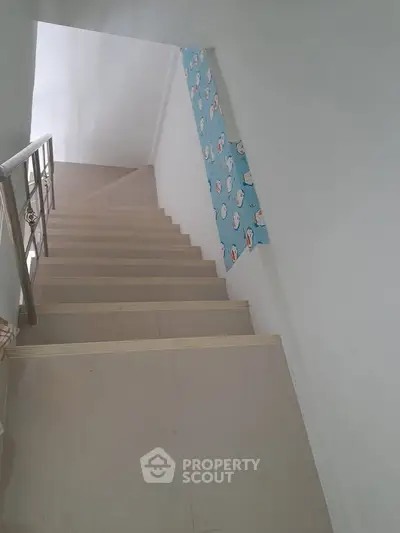 Modern staircase with sleek railing and minimalist design in a contemporary home.